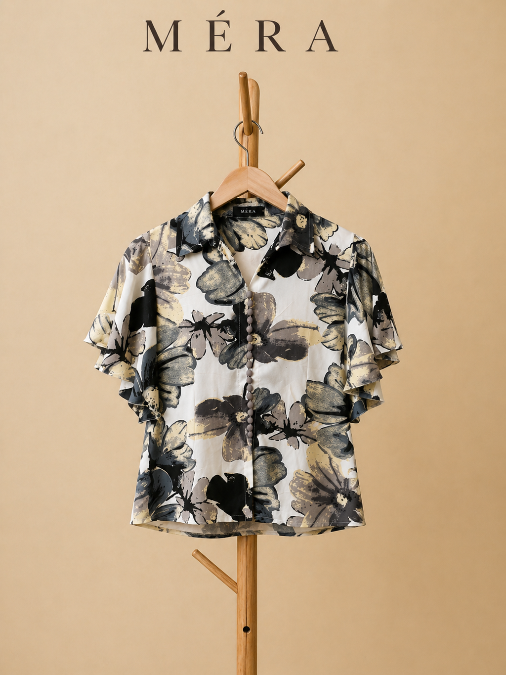 Floral patterned shirt on a hanger with 'Méra' branding against a beige background